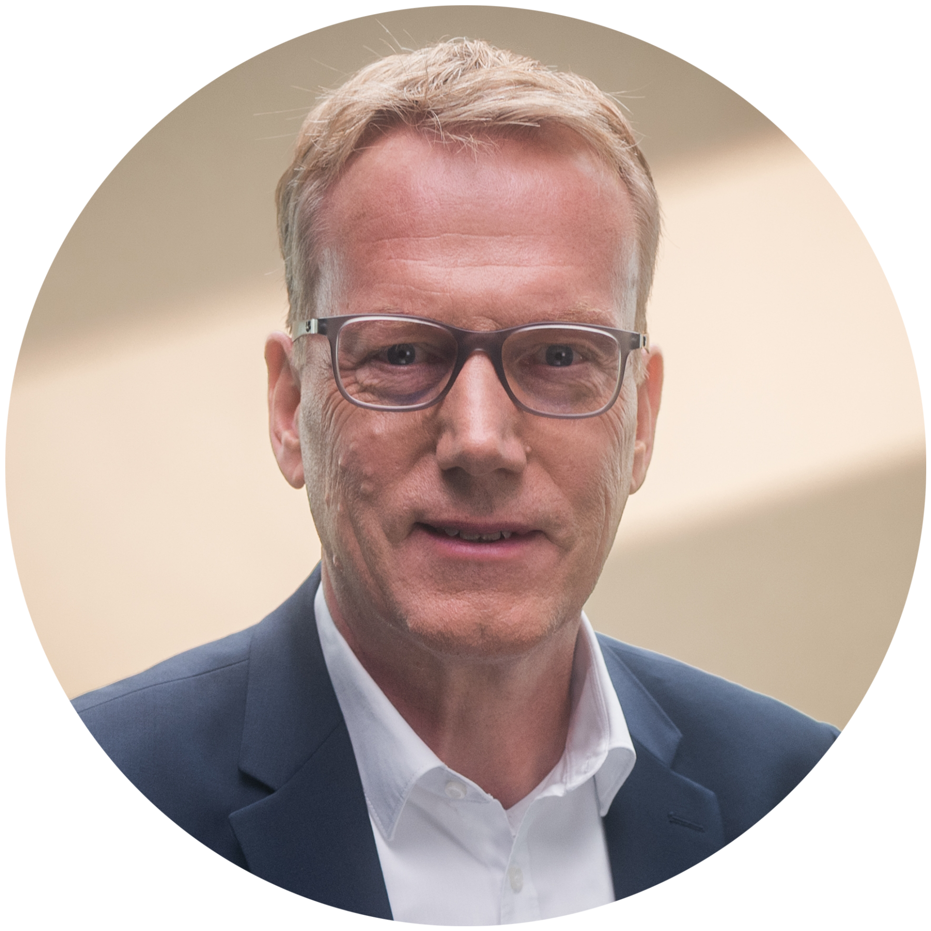 Eine Person in einem dunklen Anzug und weißem Hemd.